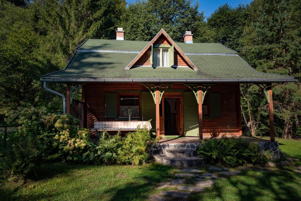 une petite maison avec une terrasse couverte sur une pelouse dans l'établissement ZSUZSI-LAK, à Sub Cetate