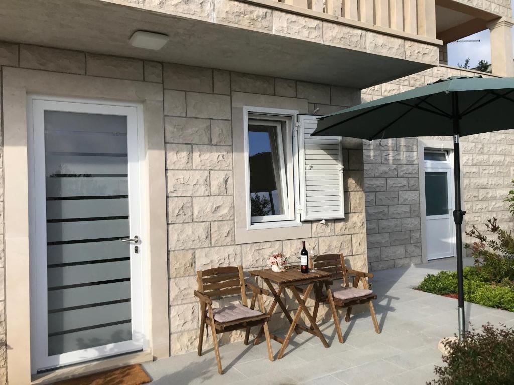 a patio with a table and chairs and an umbrella at Sweet Dreams - Studio Apartment in Dubrovnik