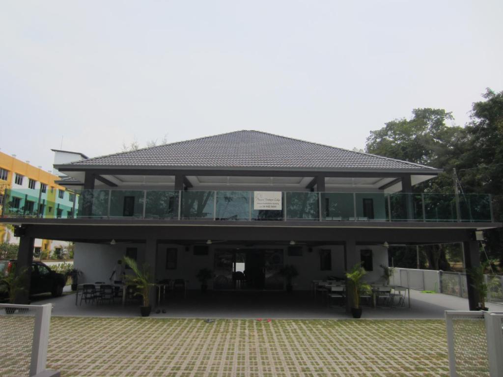 a building with a pavilion with tables and chairs at Naam Boutique Lodge in Port Dickson