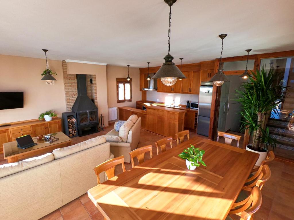 cocina y sala de estar con mesa de madera en El Rincón de Majadas, en Las Majadas