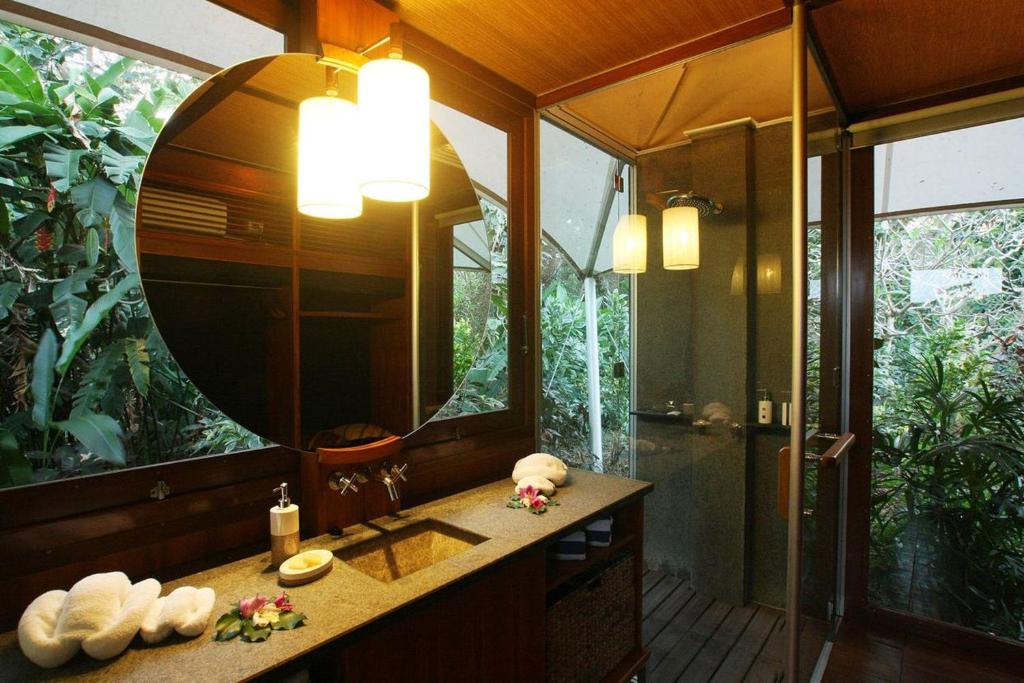 a bathroom with a mirror and a sink and a shower at The Fiji Orchid in Lautoka