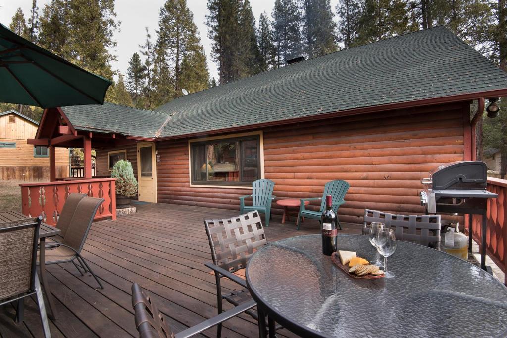 a deck with a table and chairs on a cabin at 37 Wapiti in North Wawona