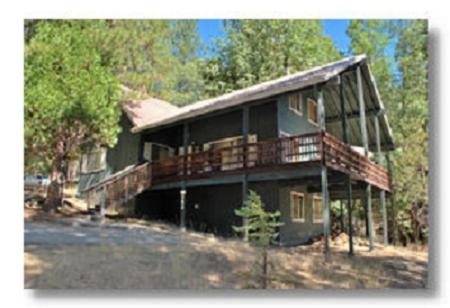 a large house with a large deck in the woods at 44R Grant's Camp in Wawona