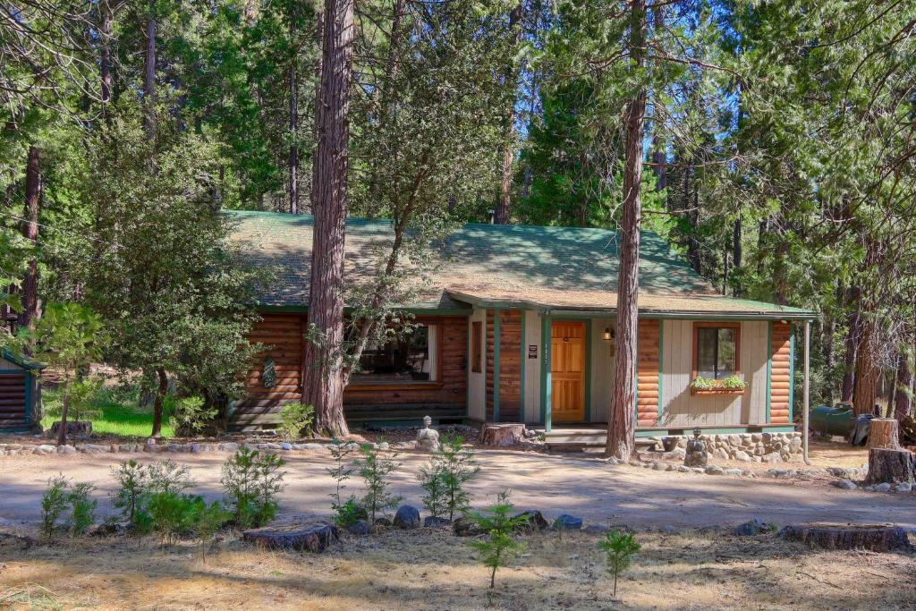 a log cabin in the woods with trees at 57 The Williams Cabin in Wawona
