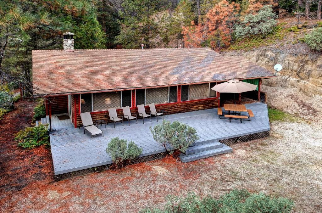 a house with a deck with chairs and an umbrella at 17A Longview in Wawona