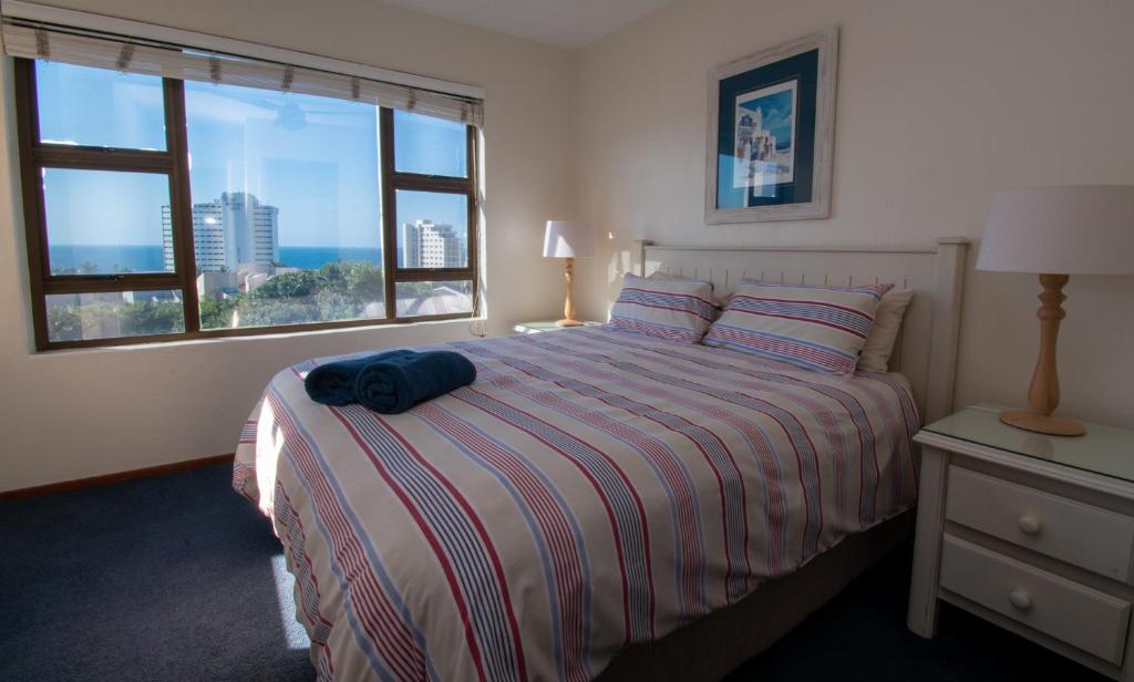 1 dormitorio con cama y ventana grande en 18 The Shades Umhlanga Rocks, en Durban