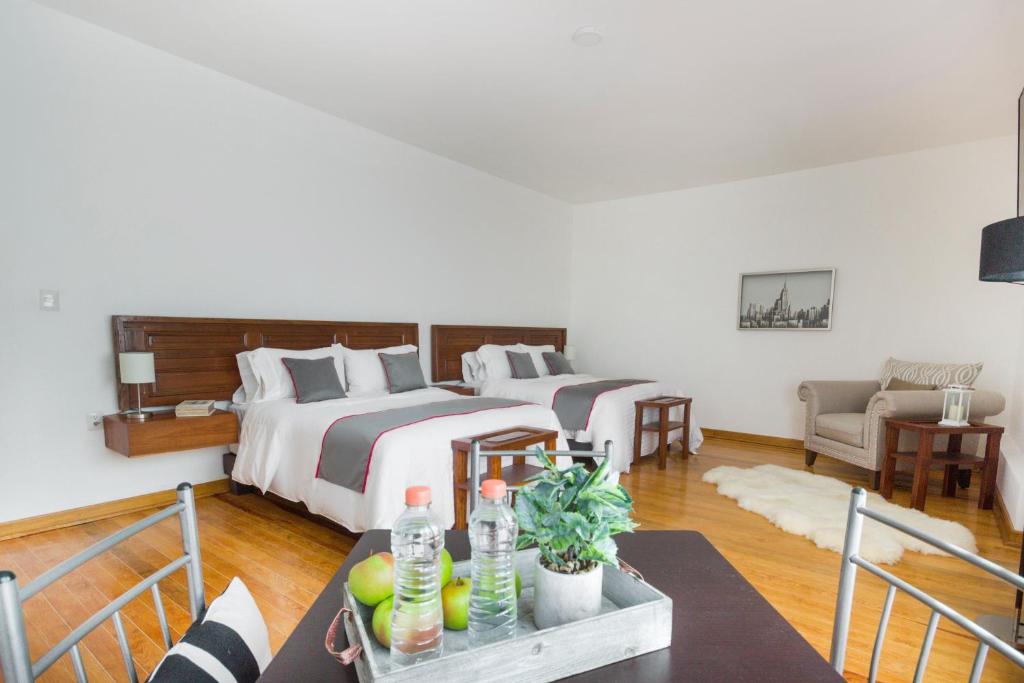 - une chambre avec 2 lits et une table avec des boissons dans l'établissement Azabu Hotel Collection, à San Luis Potosí
