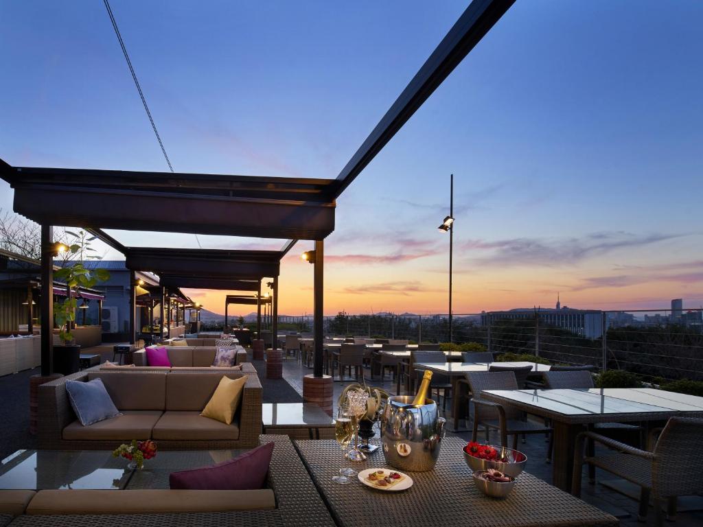 a rooftop patio with tables and couches on a building at HILLTOP RESORT FUKUOKA - Former Agora Fukuoka Hilltop Hotel & Spa in Fukuoka