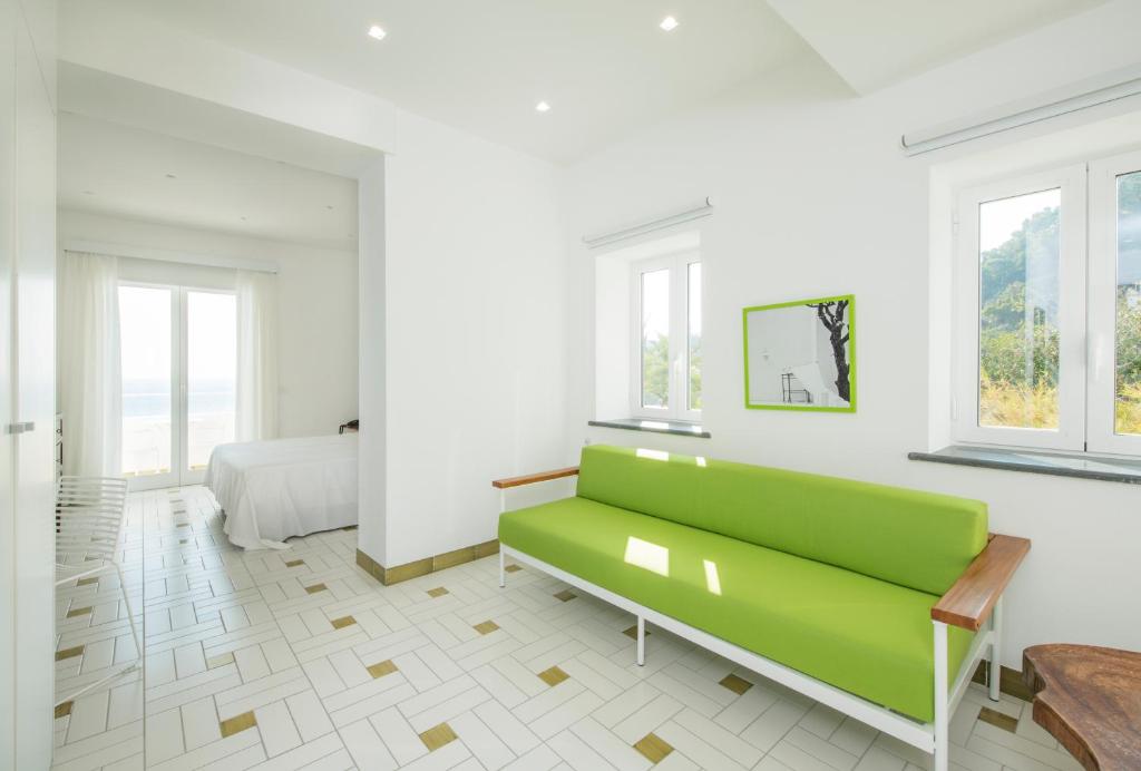biały pokój z zieloną kanapą i łóżkiem w obiekcie Apollon Club & Thermal Spa w mieście Ischia