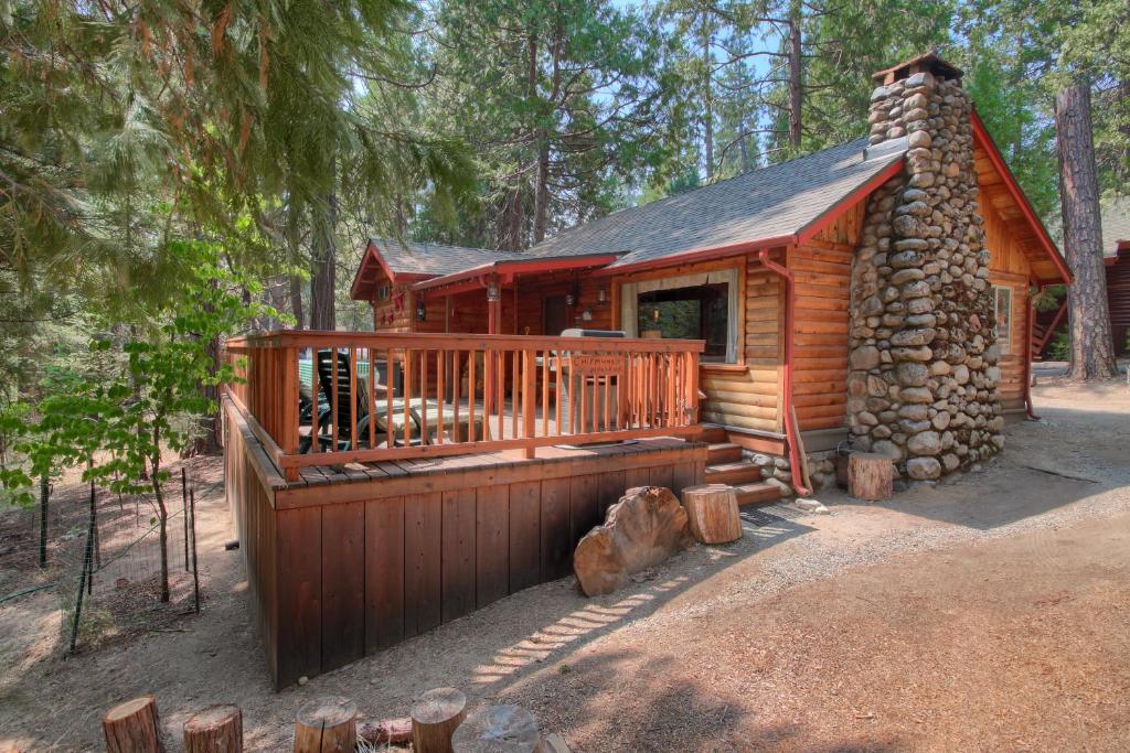 a log cabin in the woods with a deck at 16 Chipmunks Holiday in Wawona