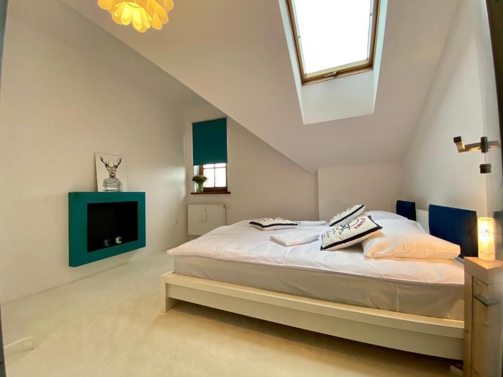 a white bedroom with a bed and a tv at Apartamenty Lemon Pepper in Jelenia Góra