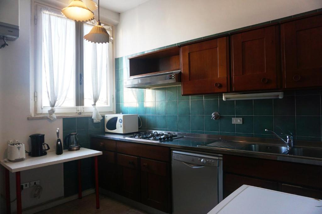 una cucina con lavandino e piano cottura forno superiore di Mamo Florence - Duomo Apartment a Firenze