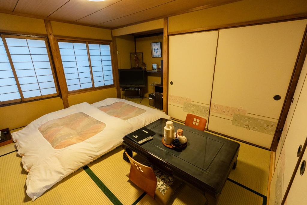 京都市にある藤家旅館のベッドとテーブルが備わる部屋