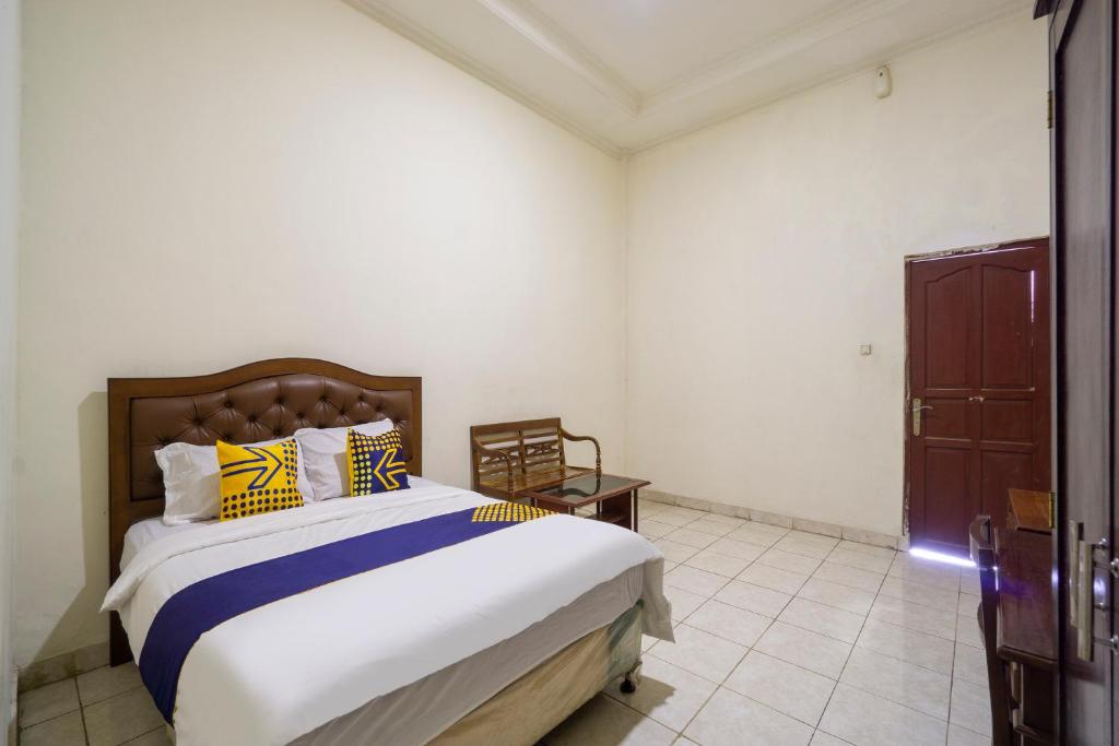 1 dormitorio con 1 cama con almohadas amarillas y azules en Super OYO 3978 Hotel Danau Indah, en Bekasi