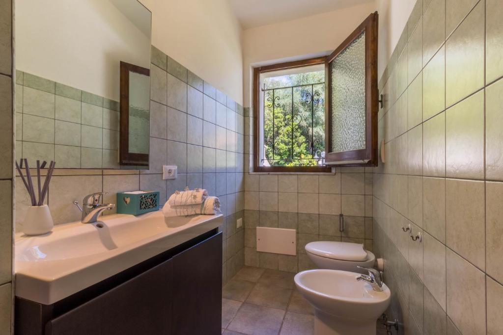 łazienka z umywalką, toaletą i oknem w obiekcie Casa Azzurra - Casa con giardino privato a Costa Rei a due passi dal mare w mieście Costa Rei