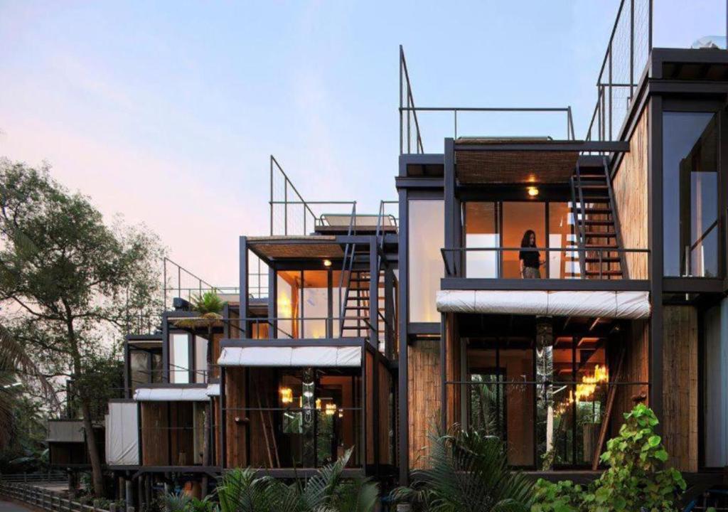 un edificio con balcones y una persona parada en la puerta en Bangkok Tree House Bang Kachao, en Bangkok