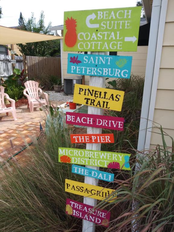 a sign for a beachside coastal cottage with colorful signs at Relaxing Beach Suite in St. Petersburg