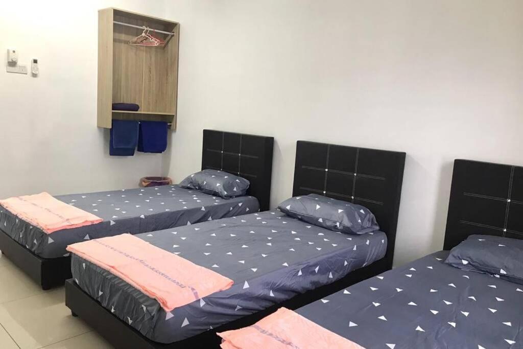 een kamer met drie bedden in een kamer bij Familyday homestay Port Dickson BBQ 3min to beach in Port Dickson