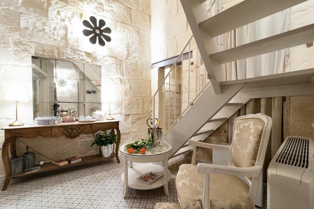 Habitación con escalera, silla y mesa. en Palazzo Mandurino luxury relais, en Zollino