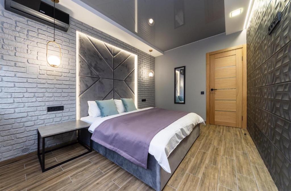 a bedroom with a bed and a brick wall at Tomas apartments in Kyiv