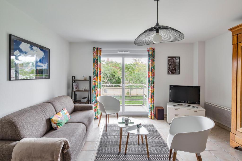 un salon avec un canapé, des chaises et une télévision dans l'établissement Les Petites Canailles - Proche de la Gare, à Nantes