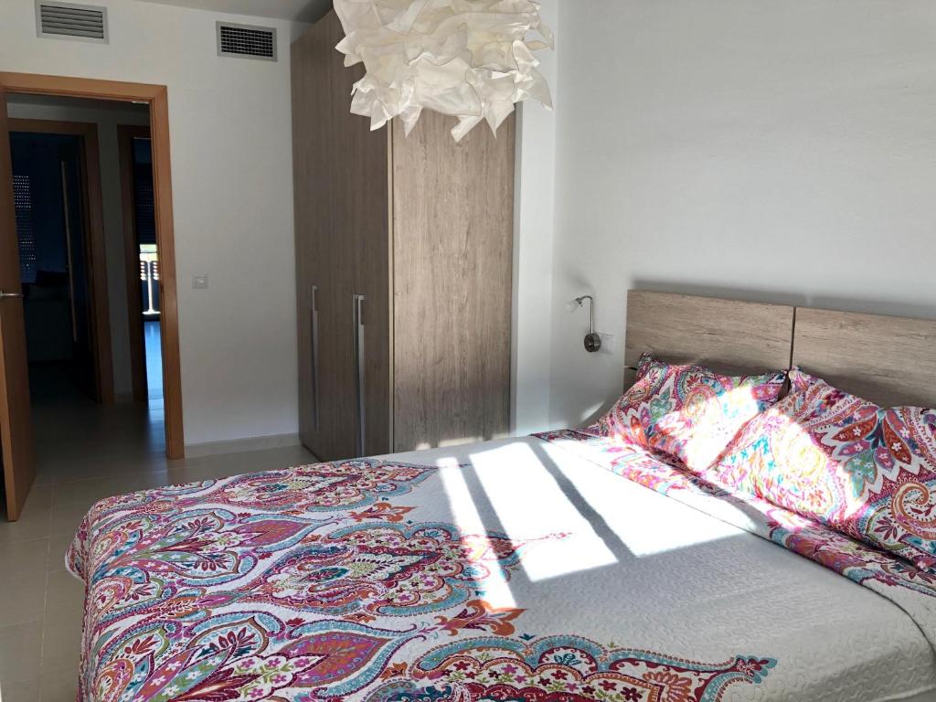 1 dormitorio con cama y lámpara de araña en Els Llorers, en Hospitalet de l'Infant