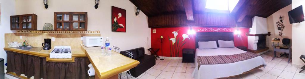 pokój z łóżkiem i kuchnią w pokoju w obiekcie Terraza Suites - Adults Only w mieście San Cristóbal de Las Casas
