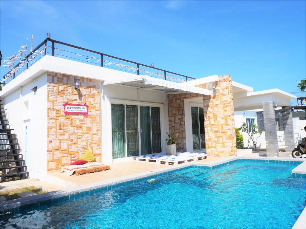 uma casa com piscina em frente a uma casa em Cheap Pool Villa Hauhin (3 BR 1 Lounge) European Kitchen em Hua Hin