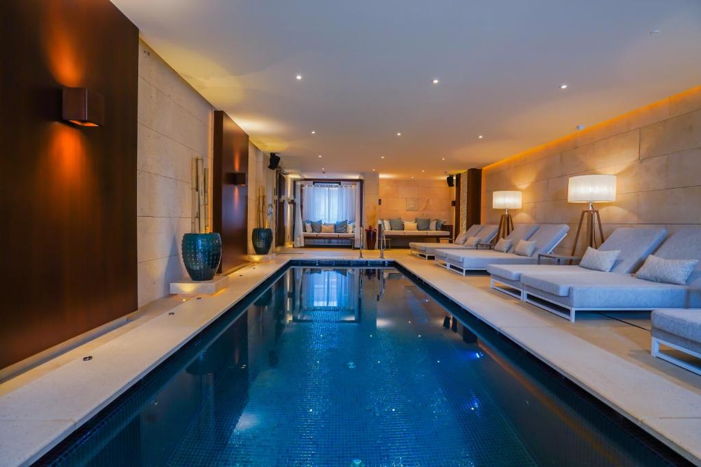 a living room with a pool and a television at Mala Garden Design Hotel in Siófok