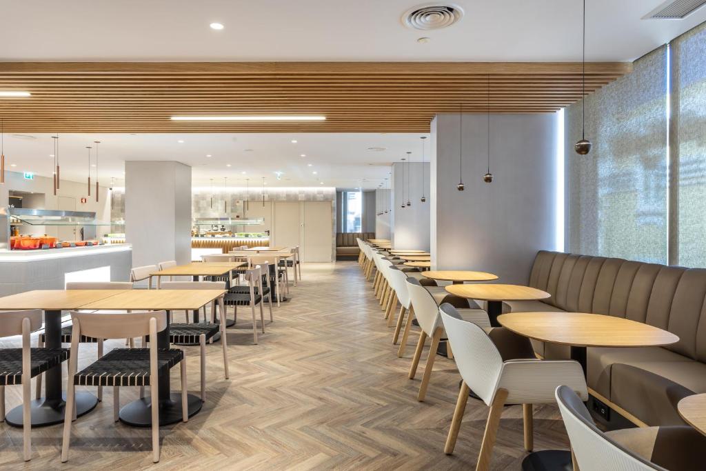 a restaurant with tables and chairs and a kitchen at Holiday Inn Lisbon by IHG in Lisbon