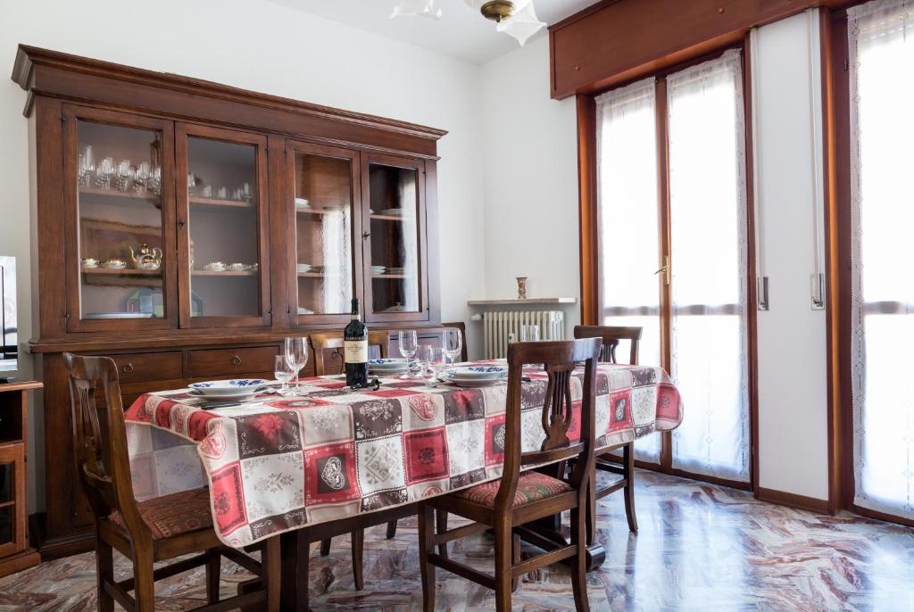 een eetkamer met een tafel en stoelen en ramen bij Parma A due passi dall'Ospedale Apartment in Parma