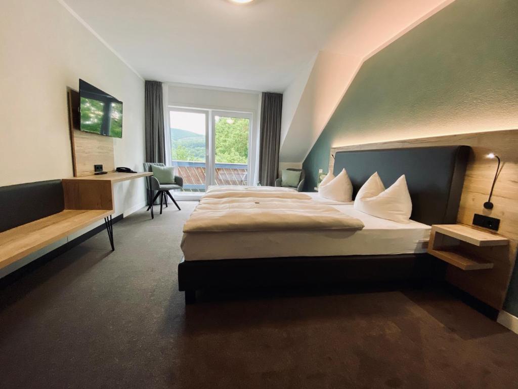 ein Hotelzimmer mit einem großen Bett und einem Fenster in der Unterkunft Hotel & Restaurant Kronenhof am Weser-Radweg in Oedelsheim