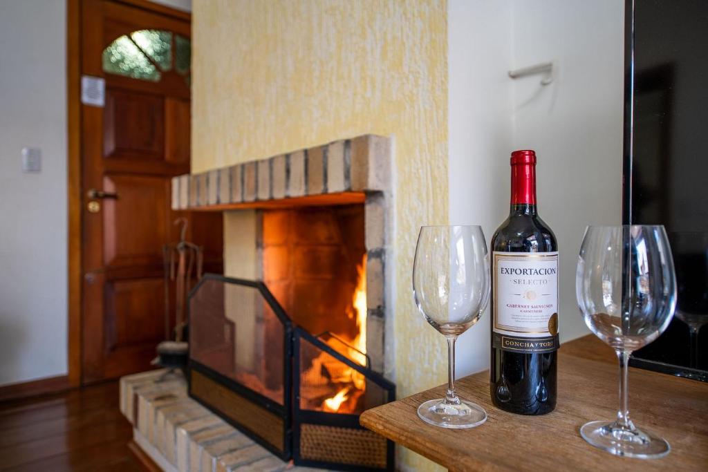 una botella de vino y dos copas de vino en una mesa en Aconchegante Apartamento no Centro de Gramado, en Gramado
