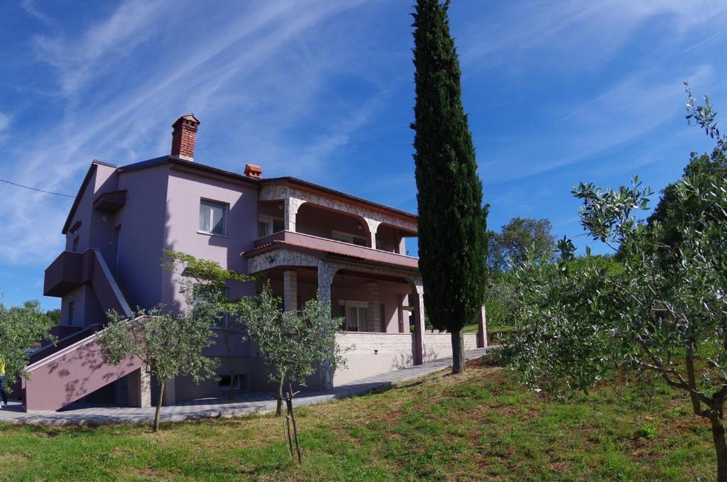 a house on a hill with a tree at Apartments Nikolina in Rakalj