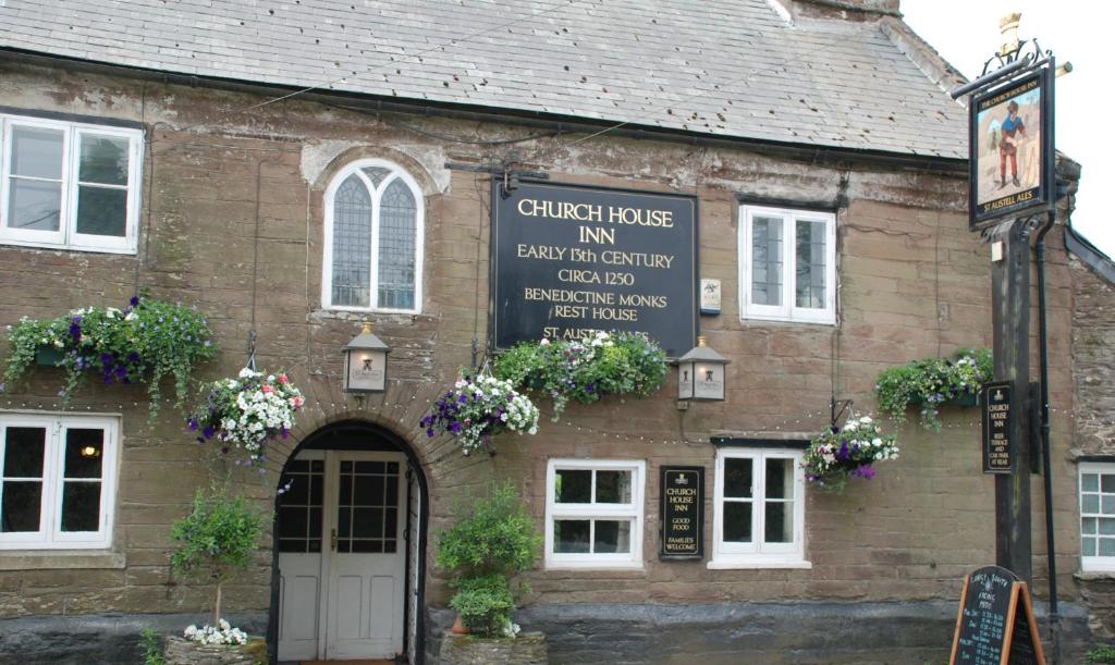 an old brick building with a sign on it at Church House Inn, Churchstow in Kingsbridge