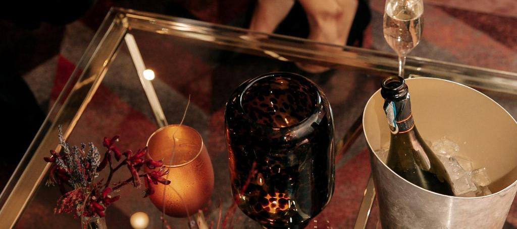 a glass table with a bottle of wine and a bucket at Hotel Hasselbacken in Stockholm
