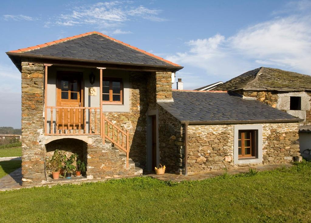 ein Steinhaus mit einer Veranda und einem Balkon in der Unterkunft Casa Aurora in Navia