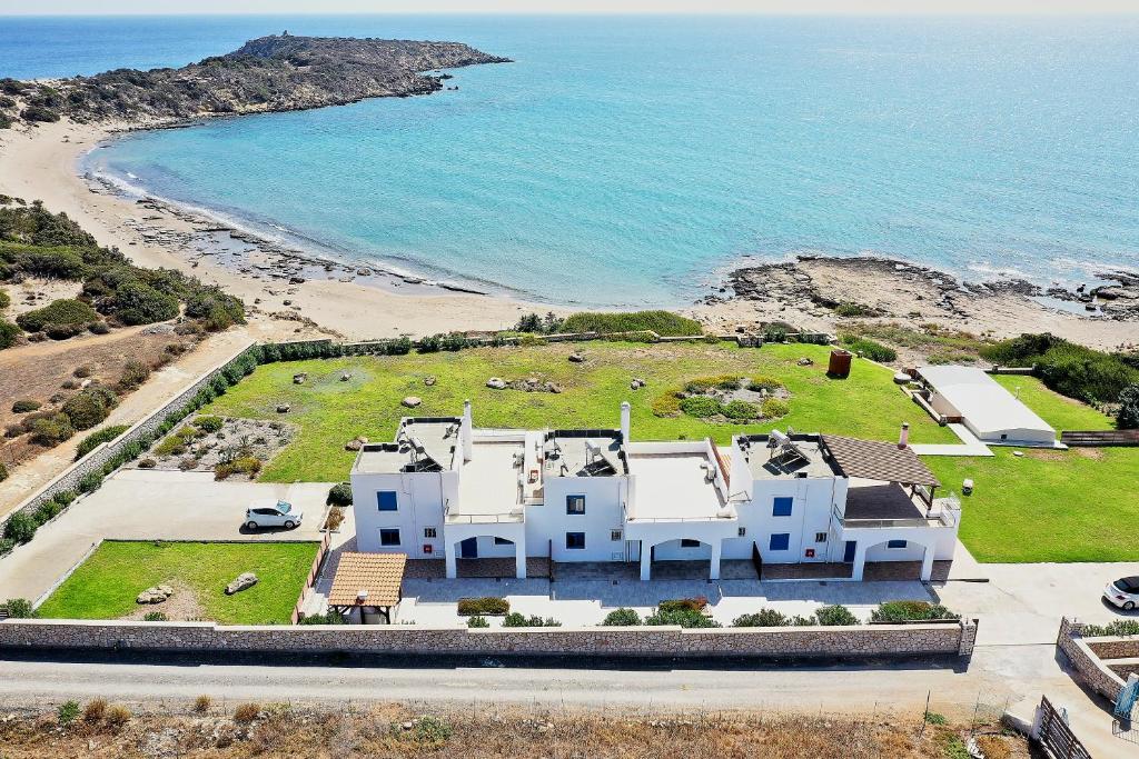 uma vista aérea de uma grande casa branca ao lado da praia em Nerida Beachfront Villas em Plimmiri