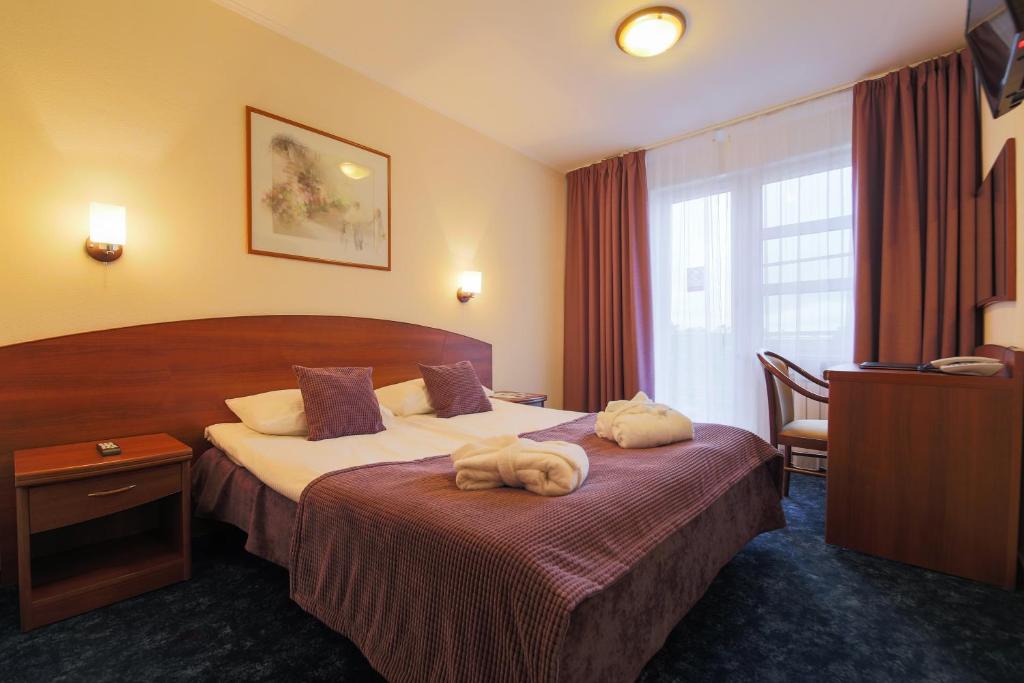 Una habitación de hotel con una cama con dos toallas. en Country Club Tropicana Park, en Brëkhovo