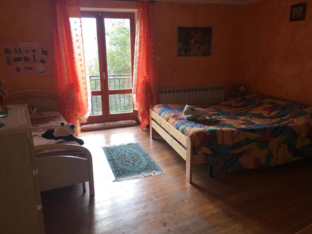 dois bichos de peluche sentados numa cama num quarto em Casa Miki em Roure Turin