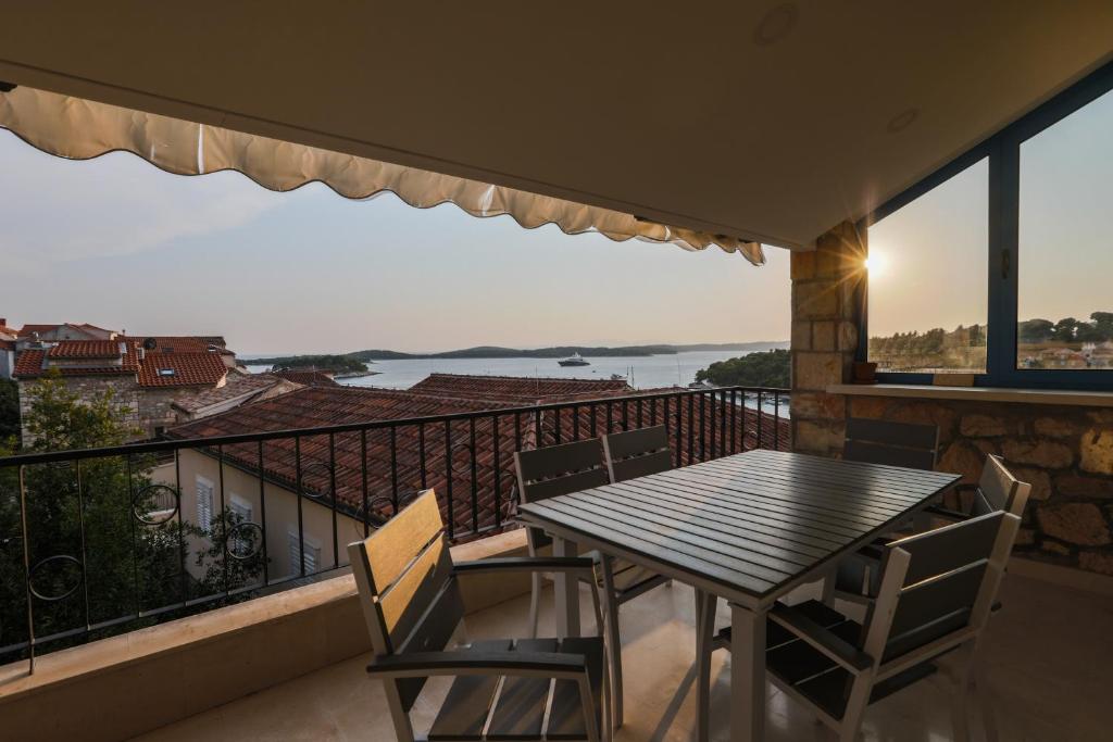 d'une table et de chaises sur un balcon avec vue. dans l'établissement Penthouse in old Dalmatian house - Flybridge, à Hvar