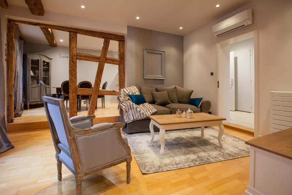 a living room with a couch and a table at Appartement Bredala avec Climatisation in Colmar