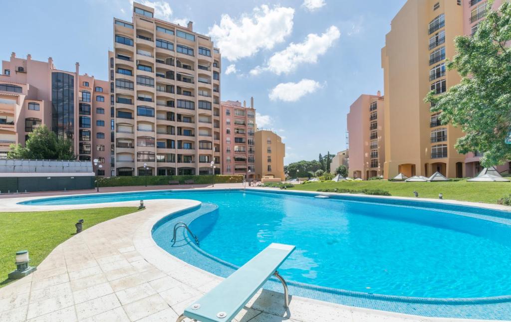 a large swimming pool with buildings in the background at HOUZE_Lovely flat with swimming pool! in Cascais