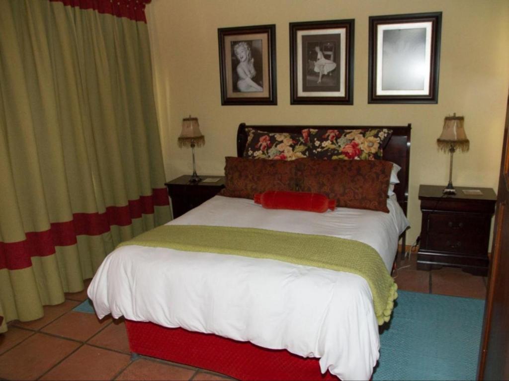 a bedroom with a bed with a red and green blanket at Jocks Cottages in Dullstroom