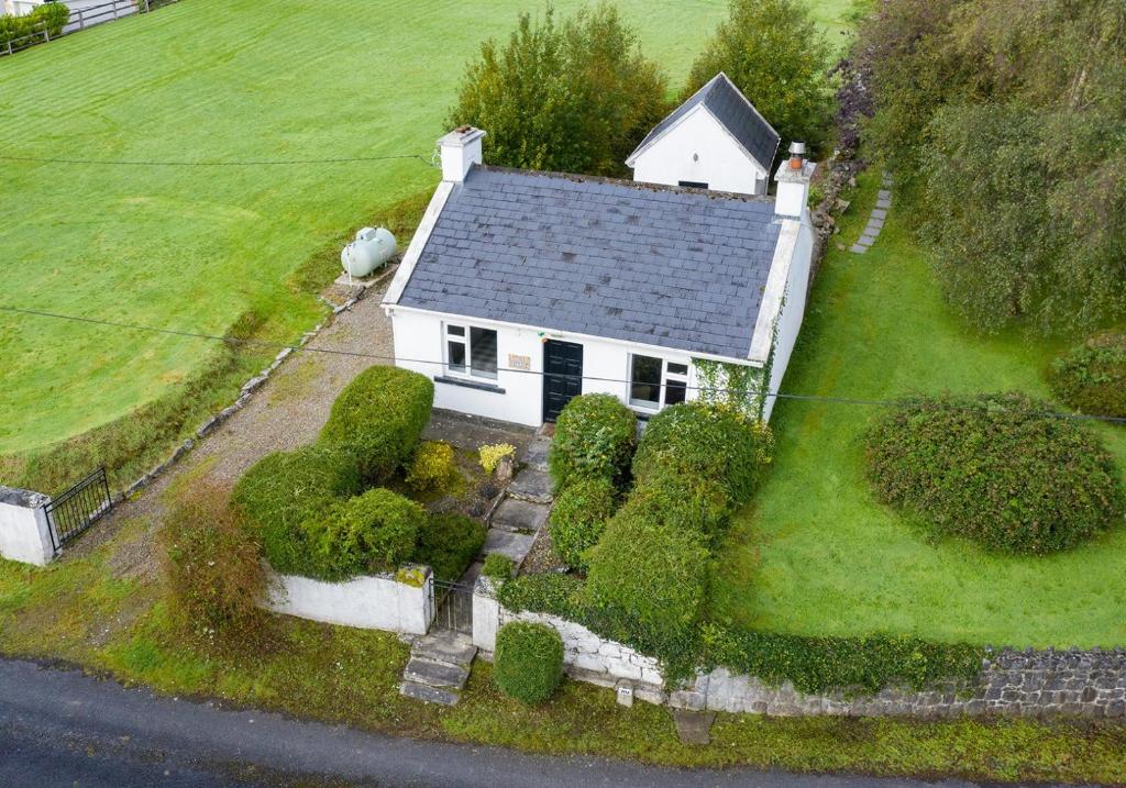 an aerial view of a white house on a green field at The Cottage @ Burkedale House in Corrofin