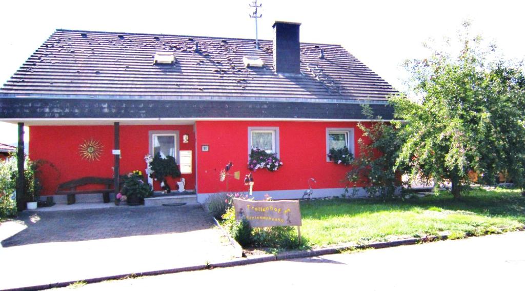 une maison rouge avec un toit noir dans l'établissement Trollenhof, à Wellendingen