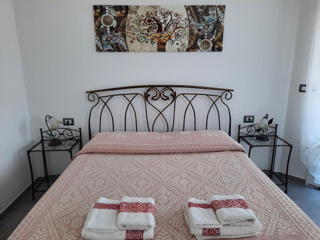 - une chambre avec un lit et 2 serviettes dans l'établissement B&B Centrale, à Tortolì