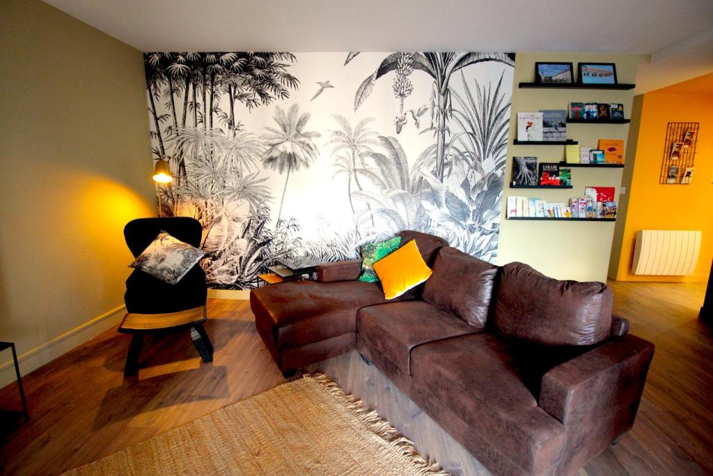 a living room with a brown couch and a wall mural at Mon Appart A GERLAND II in Lyon