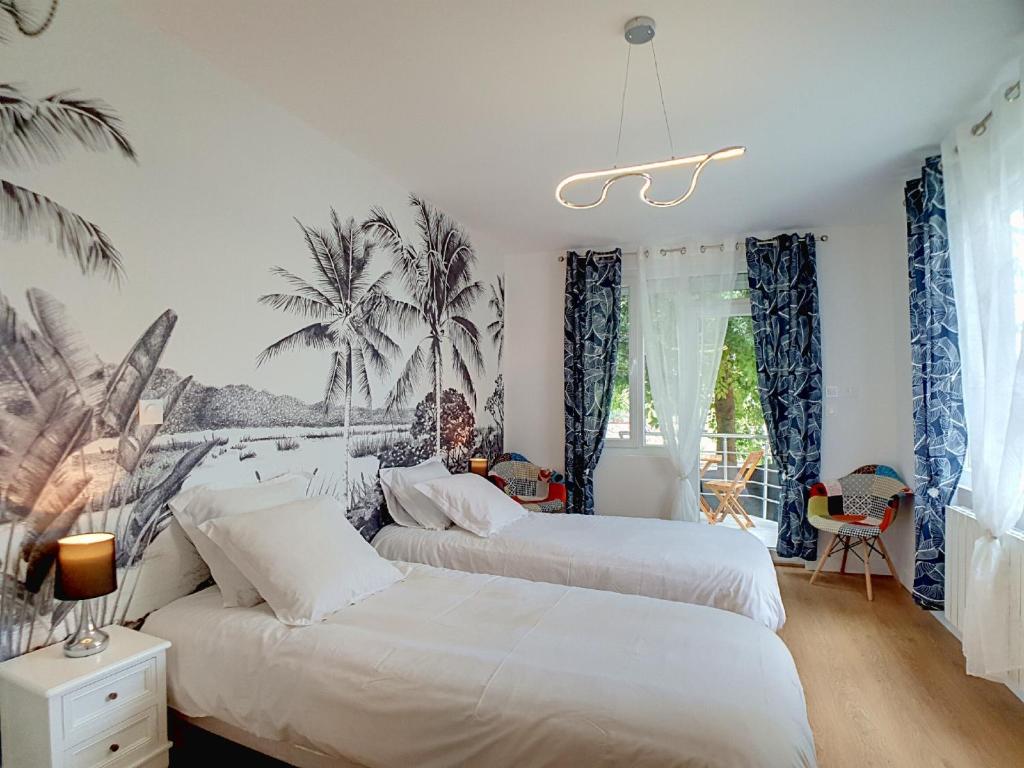 twee bedden in een slaapkamer met palmbomen aan de muur bij Stop Chez M Select Garden # Qualité # Confort # Simplicité in Saint-Fons