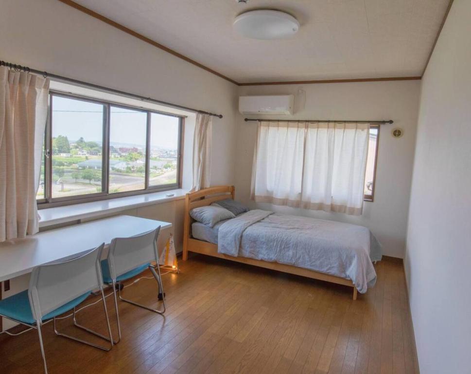 a bedroom with a bed and a desk and a window at Yasuo-shiki Ishigaki-tei #HH5x in Toyama